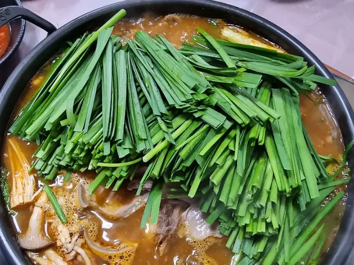 과천식당 보신탕에 신선한 부추와 채소를 듬뿍 올린 모습