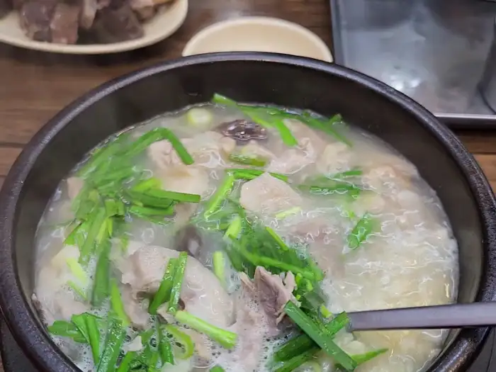 화천 식당의 푸짐한 국밥 한 그릇, 넉넉한 고기와 신선한 채소가 어우러진 모습