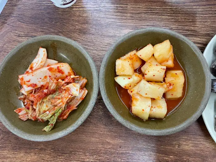 화천 식당의 김치와 깍두기, 잘 익은 김치와 시원한 깍두기가 국밥의 맛을 돋우는 모습