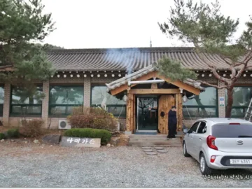 다래가든 전통 한옥 외관과 주차된 차량