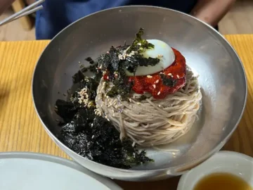 메밀 비빔 막국수에 김치 고명이 올라간 모습
