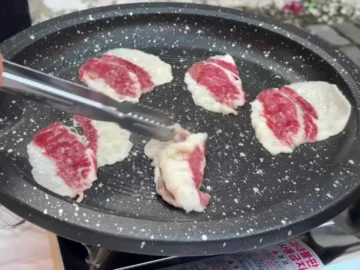 불판 위에서 노릇하게 구워지고 있는 LA갈비 조각들