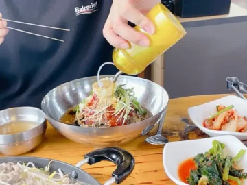 평창댁 메밀막국수 위에 소스를 붓는 모습
