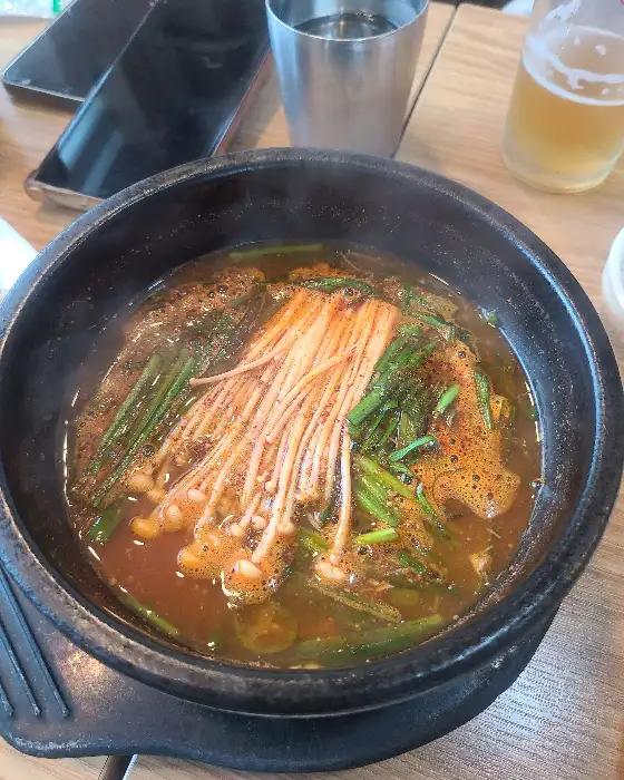 오리탕에 팽이버섯과 파가 푸짐하게 담겨 있는 모습