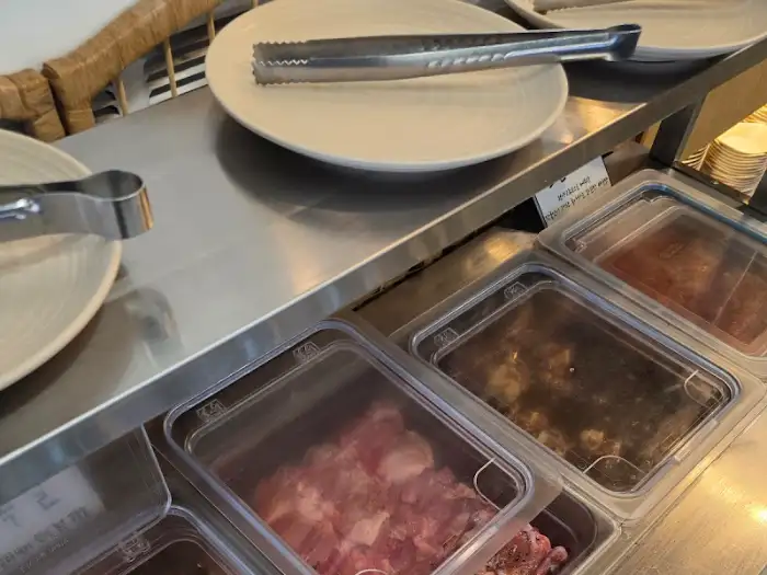 다양한 닭갈비 부위와 양념이 준비된 셀프바