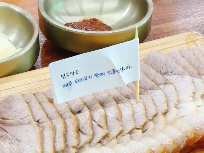 돔베고기 위에 꽂힌 '제주 돼지고기 판매 인증점' 깃발