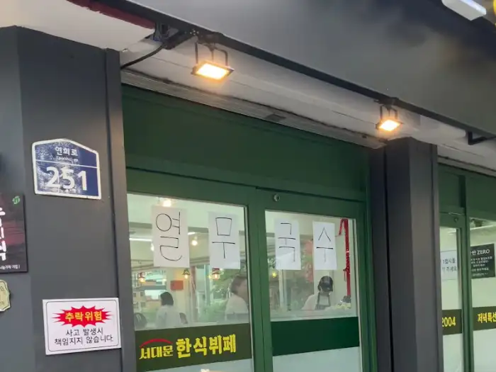 가게 입구와 간판, 메뉴판이 보이는 모습
