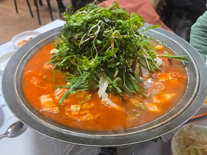 푸짐한 냉이가 가득 올라간 물닭갈비