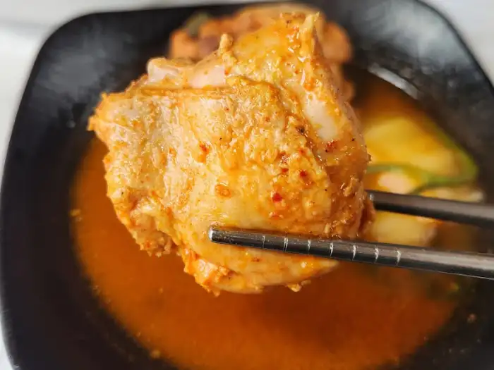 집게로 집어 올린 큼직한 닭고기