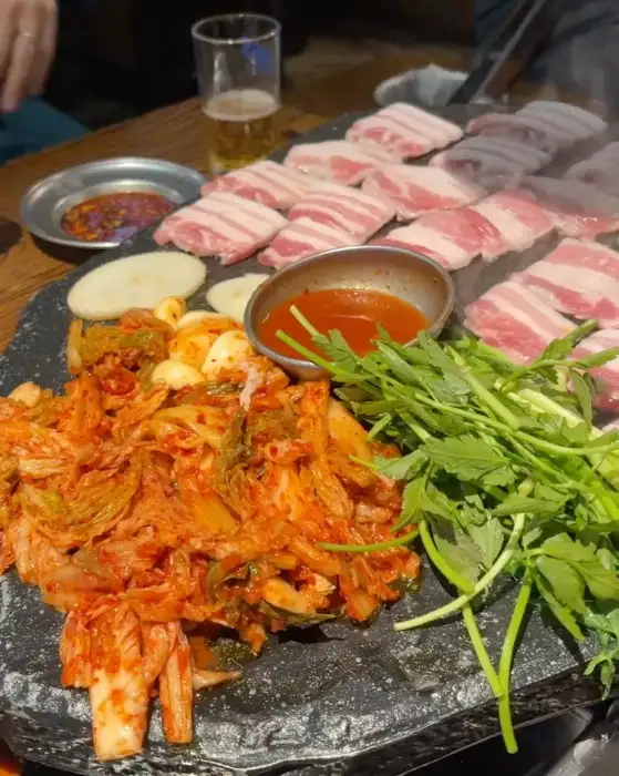 돌판에 구워진 고기와 곁들임 음식들