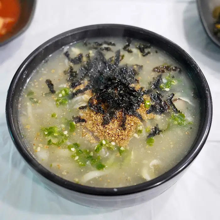 김가루가 듬뿍 올라간 옹심이와 그릇 옆의 깍두기, 열무김치