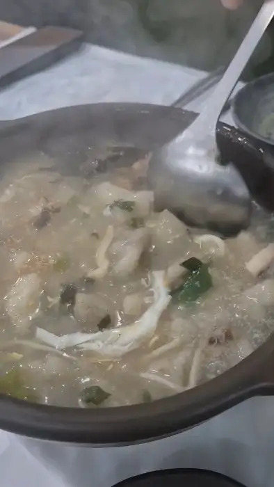 김이 나는 옹심이 그릇에 국자를 넣고 떠내는 모습