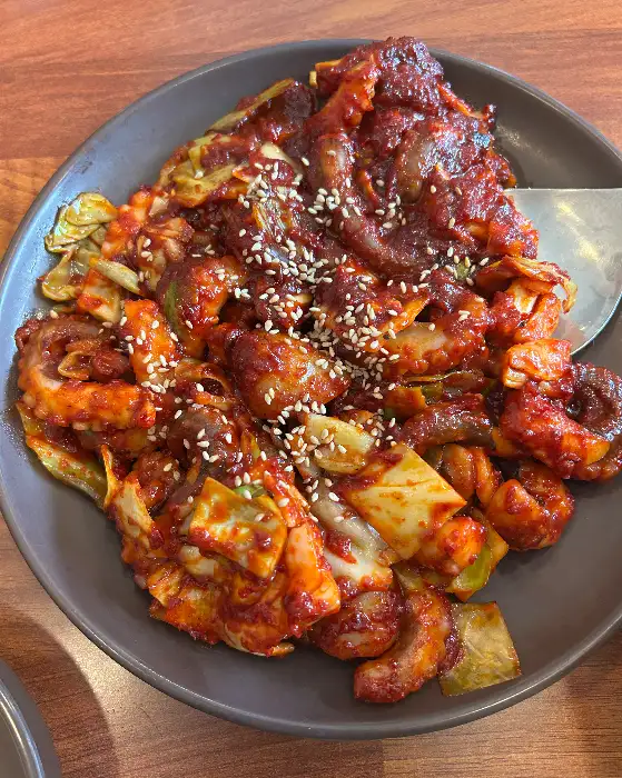 쭈꾸미 볶음이 담긴 접시, 위에 참깨가 뿌려져 있음