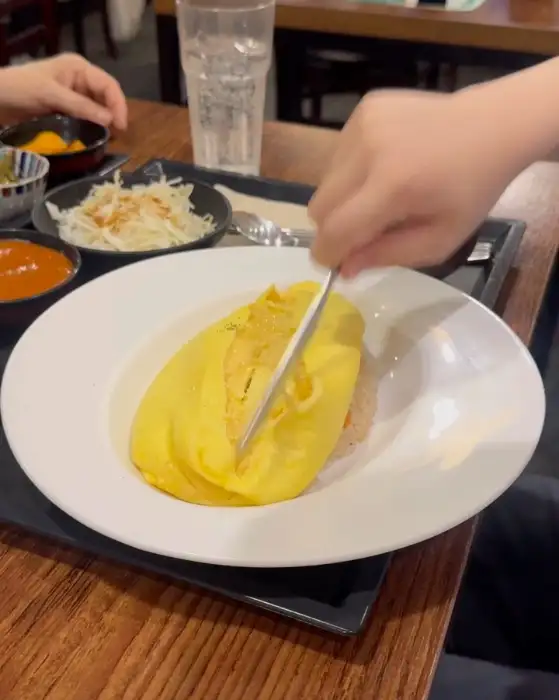 스푼으로 오므라이스를 뜨는 모습