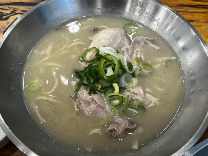 푸짐한 닭고기와 뽀얀 닭육수, 그리고 파와 채소 고명이 어우러진 닭칼국수