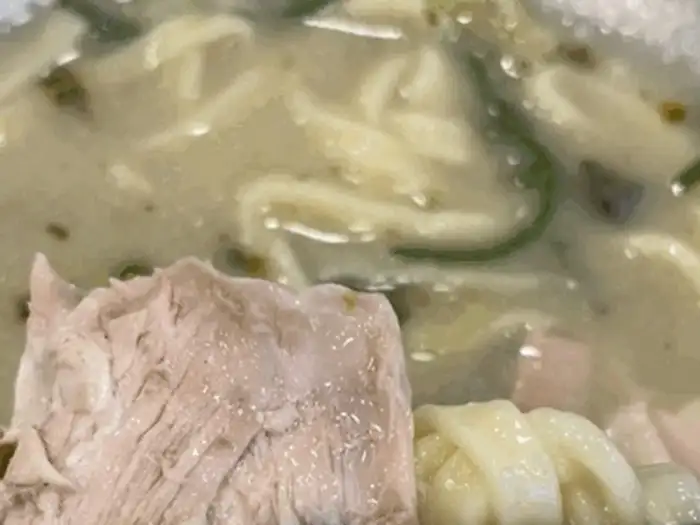 칼국수 국물과 함께 나온 닭고기 살점과 면발 클로즈업