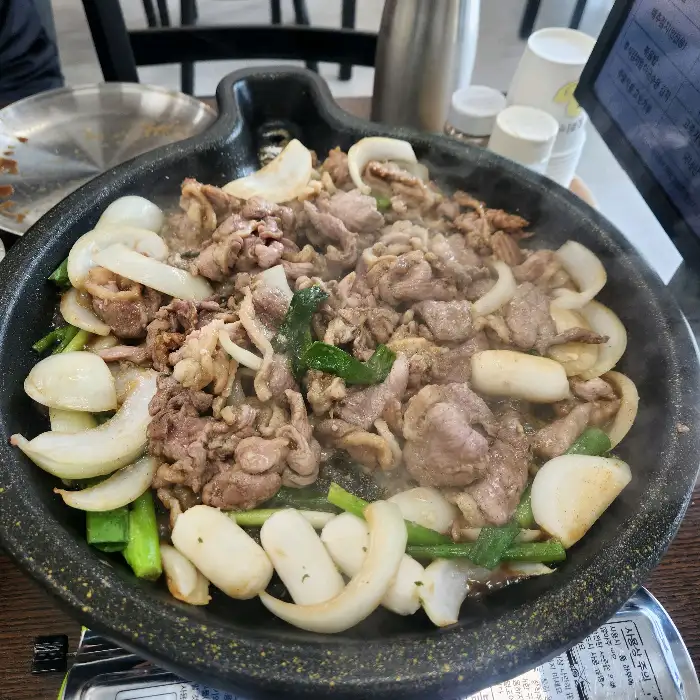 사랑채덕 평창오대산점의 오리 주물럭과 떡, 채소가 함께 조리되는 모습