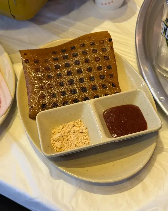 두 가지 소스가 담긴 작은 접시와 함께 놓인 납작한 음식