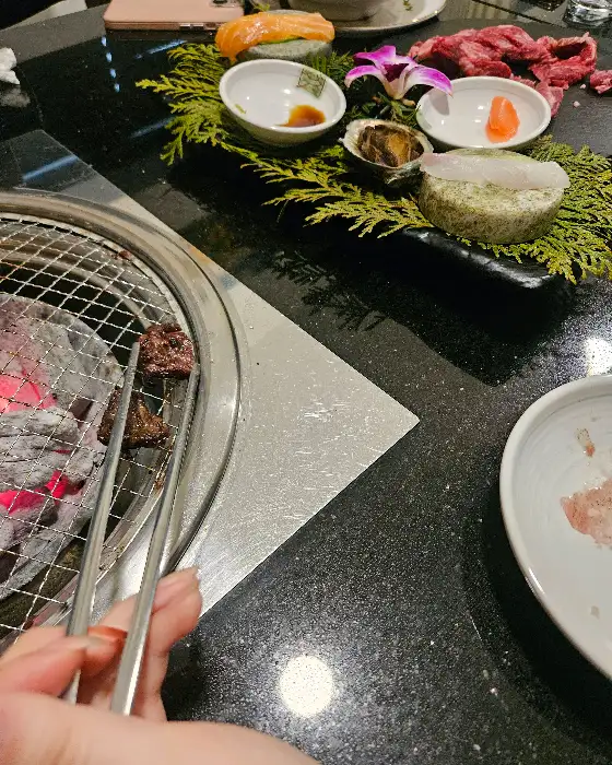 화우정에서 직원이 능숙하게 고기를 굽고 있는 모습
