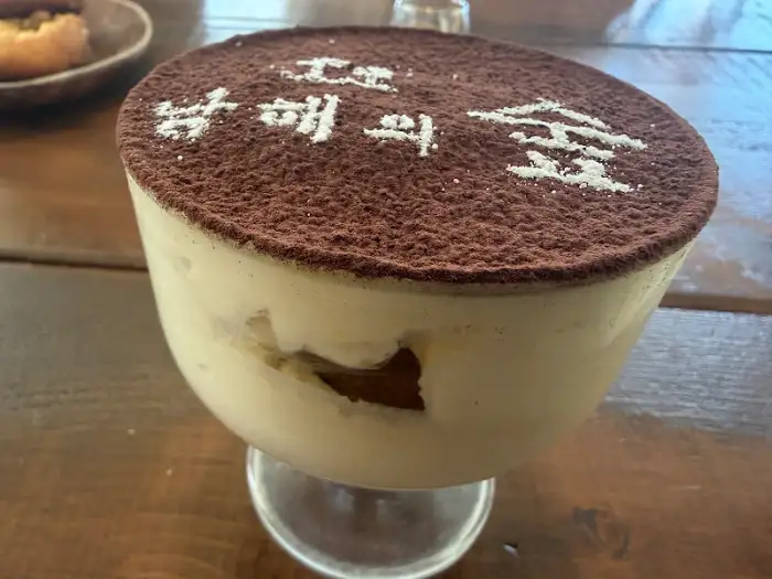 남해의숲 로고가 장식된 티라미수 디저트