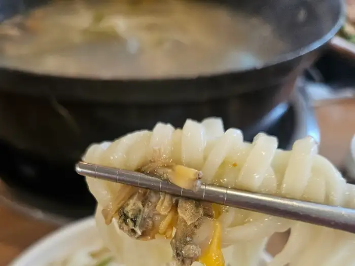 집게로 집어든 쫄깃한 칼국수 면발과 해산물