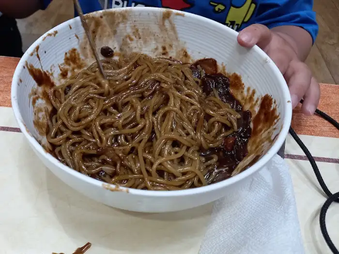 그릇에 담긴 짜장면, 면발에 짜장 소스가 넉넉히 묻어있음