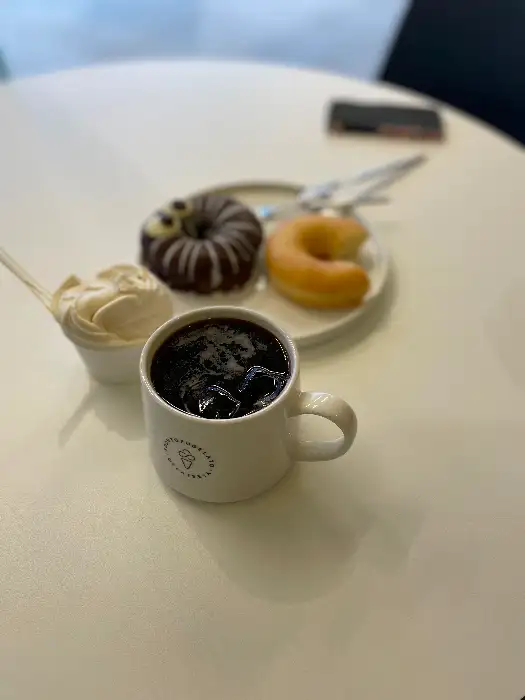 순두부젤라또 4호점의 테이블 위에 놓인 아메리카노와 도넛, 젤라또