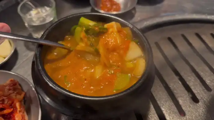끓고 있는 연탄불생고기한판의 얼큰한 된장찌개