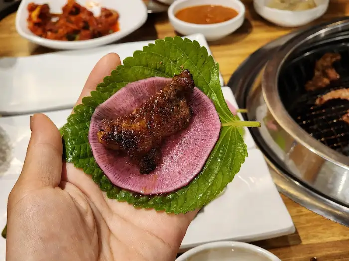 깻잎과 무쌈 위에 갈비를 얹어 먹는 모습