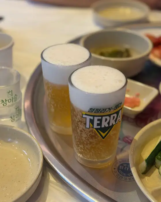 거품 가득한 시원한 맥주 두 잔이 테이블 위에 놓여 있습니다.