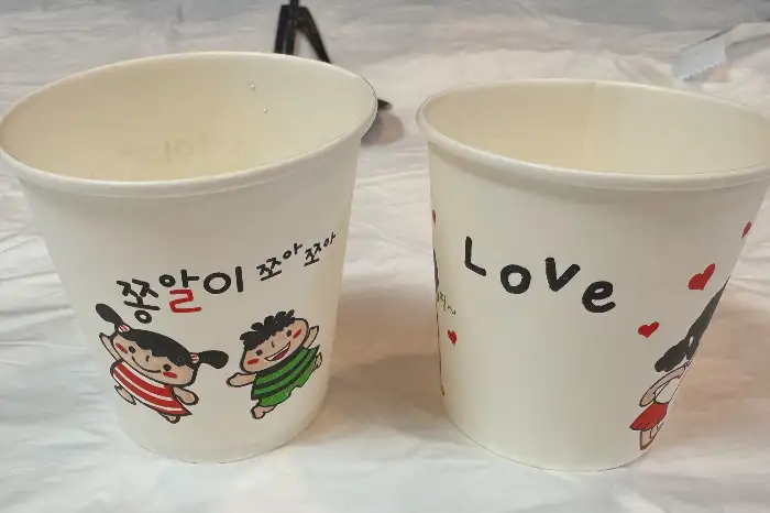 향우정의 귀여운 캐릭터가 그려진 종이컵
