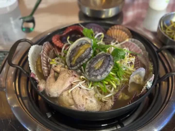 해돈집 해신탕에 푸짐하게 담긴 전복, 가리비, 문어와 닭고기