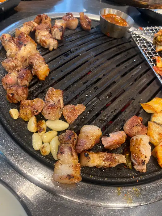 직접 구워주는 고기를 맛있게 먹고 있는 모습