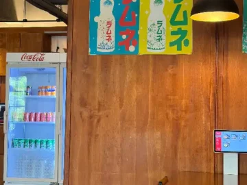 일본풍 포스터와 코카콜라 냉장고가 보이는 이이카츠 매장 내부