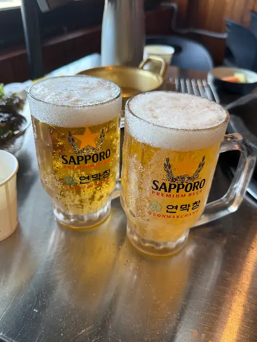 시원한 맥주잔 두 개가 테이블 위에 놓여있는 모습