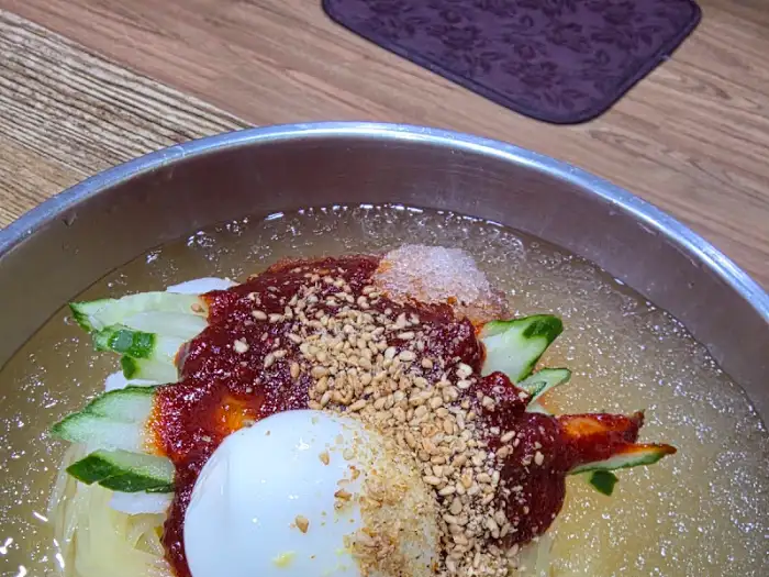 비빔밀면 위에 듬뿍 뿌려진 깨와 양념