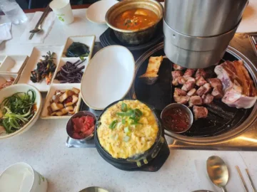 금돈가 흑돼지 구이와 다양한 밑반찬이 차려진 식탁