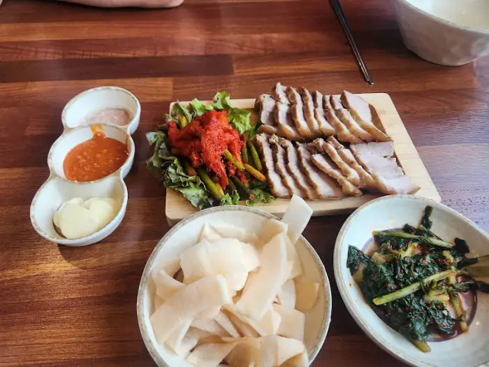 진천 원조중원탑막국수 진천이월점의 두툼한 수육과 곁들임 채소, 소스의 모습