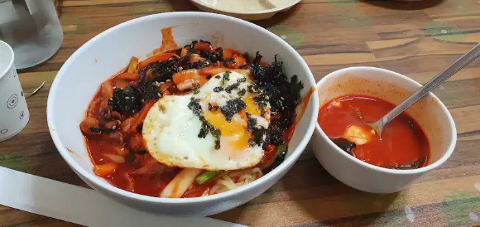 매콤한 짬뽕 국물과 함께 보이는 큼직한 계란 프라이 토핑