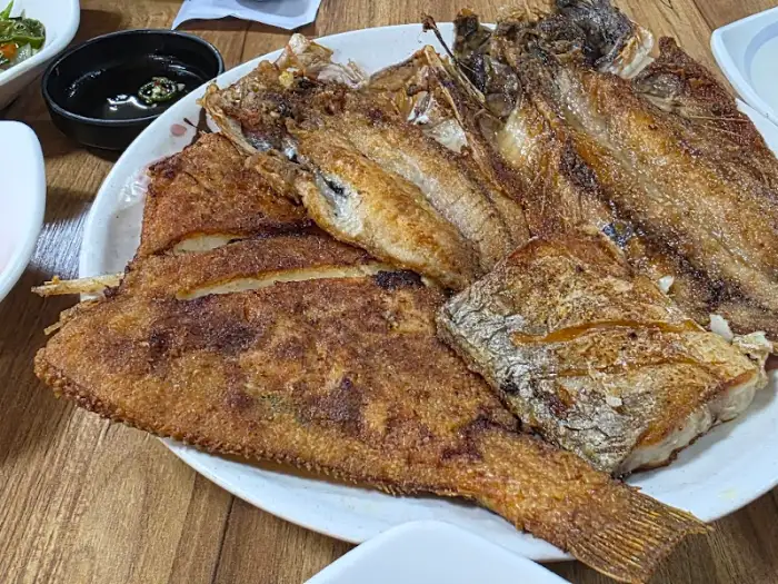 푸짐하게 차려진 다양한 밑반찬과 생선 모둠구이