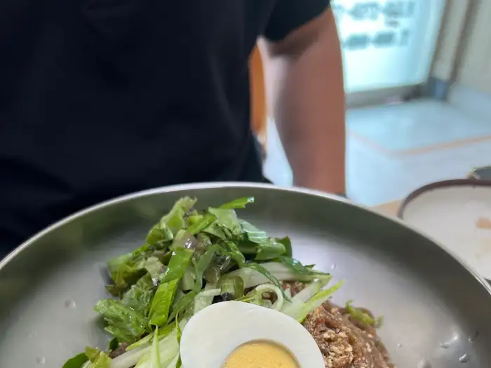 수육 한 점을 집어 올리는 모습