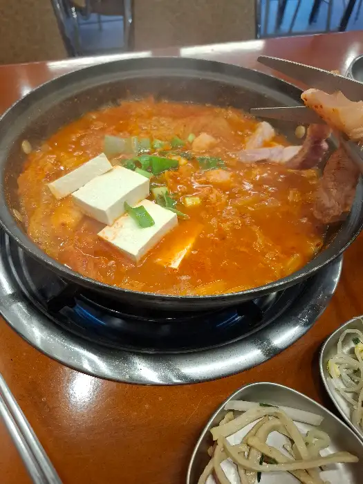 김치찌개 국물의 깊은 맛을 묘사하는 사진.