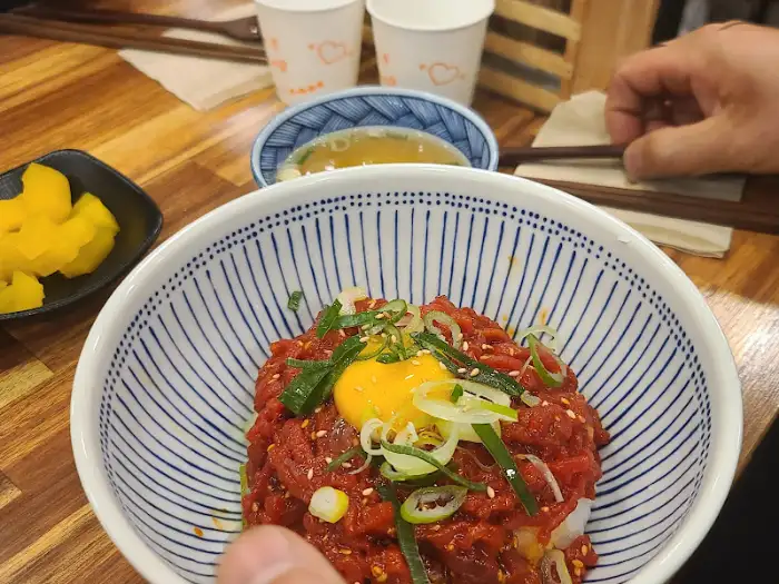칸도라멘의 붉은 양념과 노른자가 돋보이는 육회 비빔밥