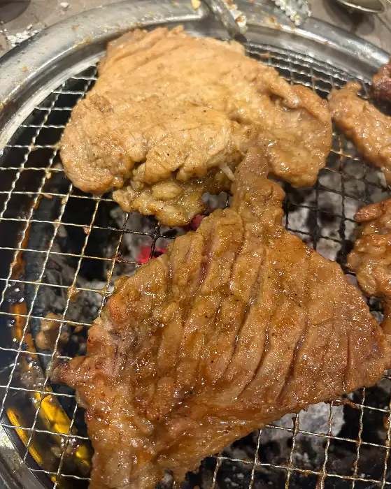 오돈에서 숯불에 구워지는 양념 갈비의 먹음직스러운 모습