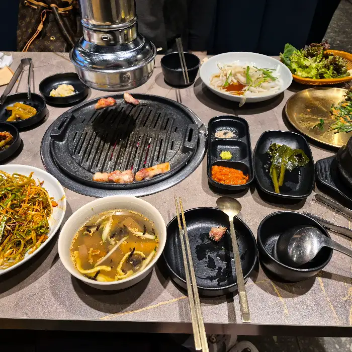 오돈의 푸짐한 한상차림, 다양한 밑반찬과 함께 메인 메뉴가 준비되어 있습니다.