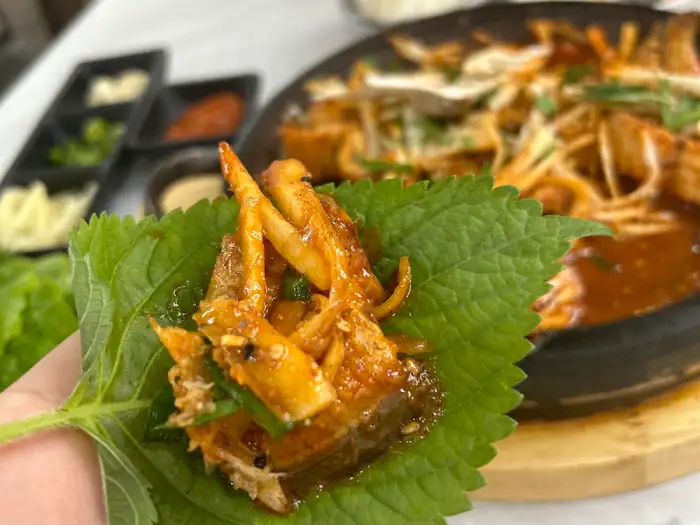 깻잎쌈에 싸인 매콤한 퓨전 요리 한 점