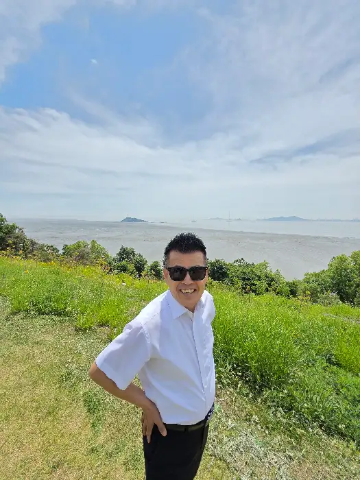 푸른 잔디와 탁 트인 풍경을 배경으로 웃고 있는 남성