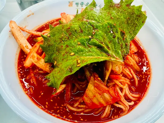 망향비빔국수 본점 매장 내부 모습, 넓은 테이블과 많은 손님들로 활기찬 분위기