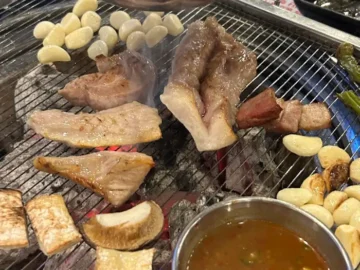 서울 용산 숨은 보석, 식껍 용산점에서 맛본 돼지고기의 진수 식껍 용산점 숯불 위에 구워지는 다양한 돼지고기 부위와 마늘