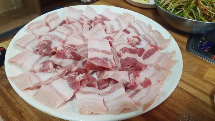 신선한 생삼겹살이 먹기 좋게 썰려 접시에 담겨 있는 모습